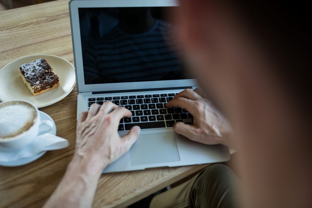 man using laptop coffee shop